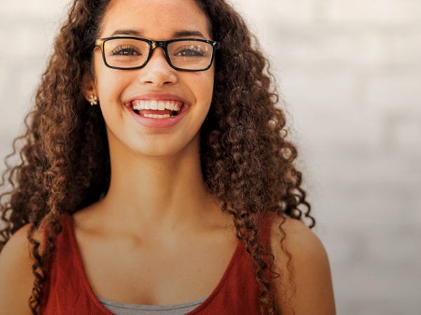 Young female with glasses and curly hair smiling