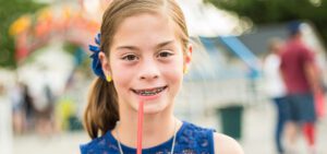 Young girl with braces having a soda for a drink